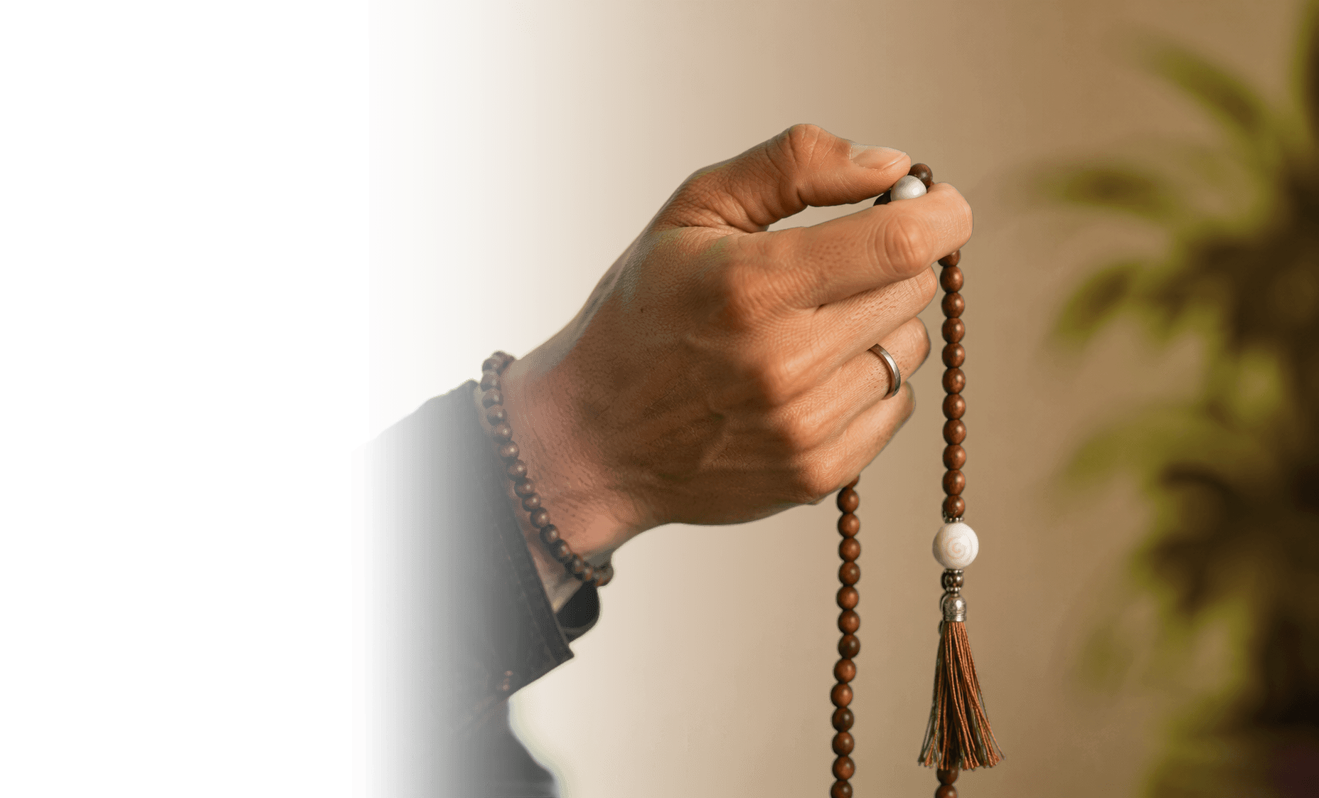 Hand holding mala beads in a quiet moment of practice